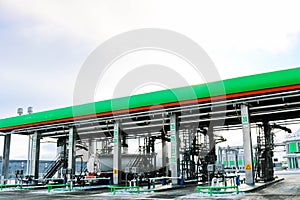 Large green industrial gas station for refueling vehicles, trucks and tanks with fuel, gasoline and diesel in the winter