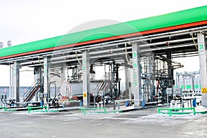 Large green industrial gas station for refueling vehicles, trucks and tanks with fuel, gasoline and diesel in the winter