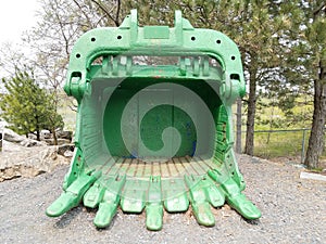 Large green metal excavating or mining machine part