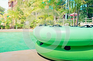 Green swim ring for water park slide on water park pool side