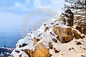 A large grey rock face on the edge of a cliff at a height of and a dramatic sky in the clouds