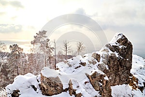 A large grey rock face on the edge of a cliff at a height of and a dramatic sky in the clouds