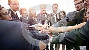 large group of business people standing with folded hands togeth