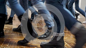 Large group of children synchronously dance in blue jeans and black boots. training