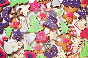 Large group of delicious, homemade Christmas honey cookies with fondant in many different shapes and colors