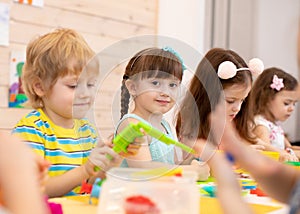 Large group of kids play with modeling clay