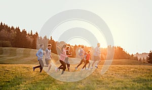 Large group of people cross country running in nature.