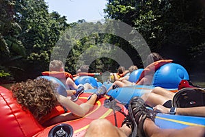 Large group of people floating down a scenic jungle river in Belize Central America on a natural Cave Tubing adventure