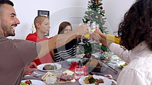 Large group of people toasting wine at christmas party celebration at home