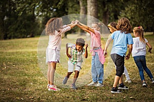 Large group of school kids having fun in nature.  Carefree children playing in the park