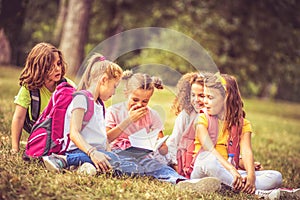 Large group of school kids having fun in nature Story time