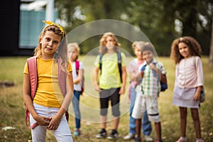 Large group of school kids in nature. Portrait of school girl. Focus is on foreground.  Group of school children in the park