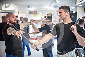 Large group of students practice filipino eskrima stick fight techniques