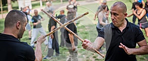 Large group of students practice filipino eskrima stick fight techniques