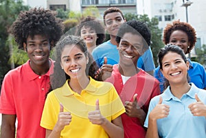 Large group of successful international team of young adults showing thumb