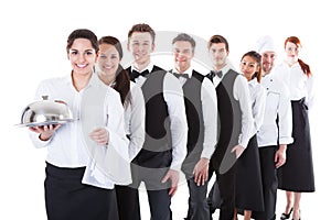 Large group of waiters and waitresses standing in row