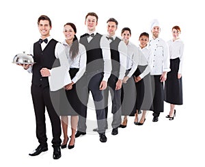 Large group of waiters and waitresses standing in row