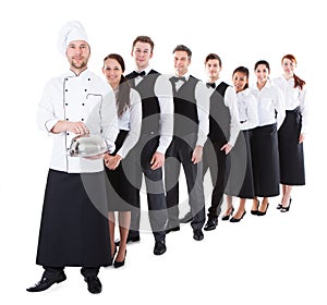 Large group of waiters and waitresses standing in row photo