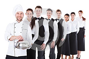 Large group of waiters and waitresses standing in row photo