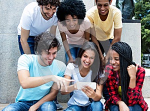 Large group of young adults gaming with phone