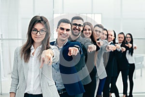 Large group of young business people are pointing at you