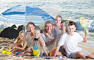 Large happy family on beach sitting on weekend