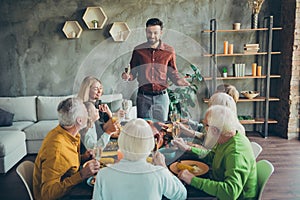 Large happy family gather party celebrate thanksgiving day sit table enjoy roast chicken meal man stand hold champagne