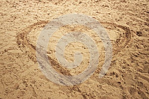 Heart shape drawn in sand of the sea beach for natural, symbol, tourism, holiday or conceptual designs.