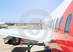 Large heavy modern passenger widebody airplane side close up detailed exterior view with exit door handle, passenger photo
