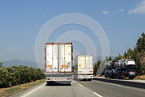 Large and heavy vehicles traveling side by side on the highway. traffic generated trucks.