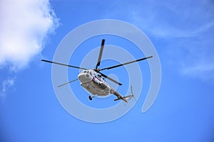 A large helicopter is flying in the blue sky