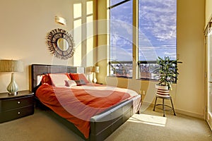 Large high ceiling bedroom with red bed.