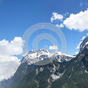 Large high mountains with a large and lush cloud in the sky