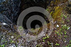 A large hole in the ground, an abandoned well, a hole in the ground