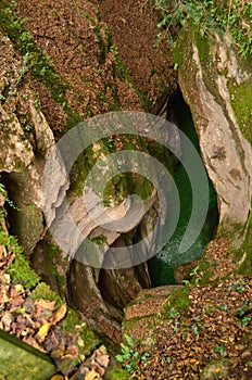 Large hole with water below in the countryside photo