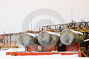 Large horizontal shell-and-tube tanks heat exchangers with liquid at an industrial petroleum refining petrochemical chemical plant