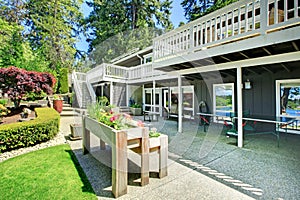 Large house back yard with two decks and flower boxes.