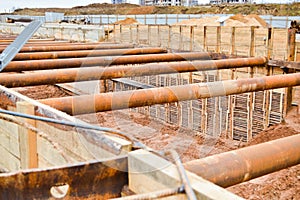 A large huge ditch pit tunnel with reinforcing structures from thick iron pipes of beams and structures at the construction site