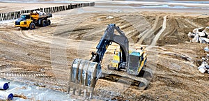 large hydraulic excavators and dumper working as a team on a construction site