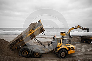 large hydraulic excavators and dumper working as a team on a construction site