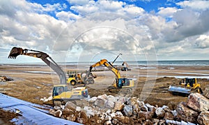 large hydraulic excavators and dumper working as a team on a construction site