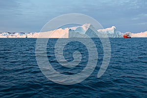 Large iceberg and boat in the Disko Bay, Greenland. The source of these icebergs is the Jakobshavn glacier.