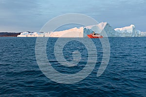 Large iceberg and boat in the Disko Bay, Greenland. The source of these icebergs is the Jakobshavn glacier.