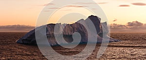 Large Iceberg Floating in Sea at Dusk