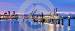 Large illuminated mooring pier in a river at twilight