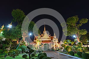 Large illuminated temple Wat Arun after sunset seen accross river Chao Phraya Bangkok