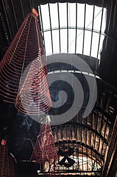 Large incense coils burning hanging from the ceiling of a Vietnamese Buddhist temple
