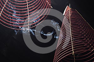 Large incense coils burning hanging from the ceiling of a Vietnamese Buddhist temple