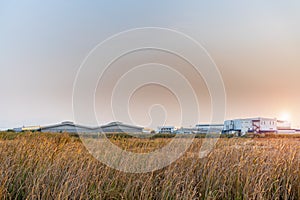 Large industrial factory building in the middle of the field on beautiful sunshine and blue sky at sunset of evening day