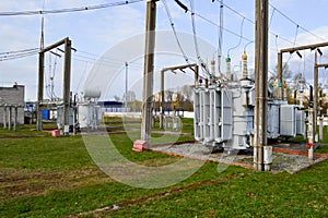 Large industrial iron metal transformer substation with transformers and high-voltage electrical equipment and wires with surge